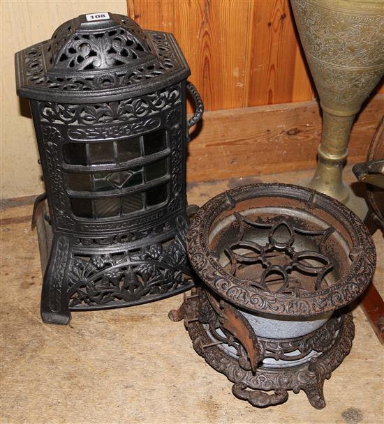 Two cast iron stoves, one with stained glass panel